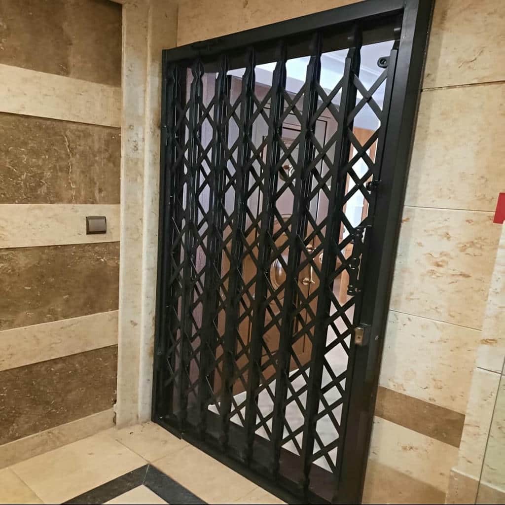 حفاظ درب آکاردئونی مشکی کنار درب چوبی