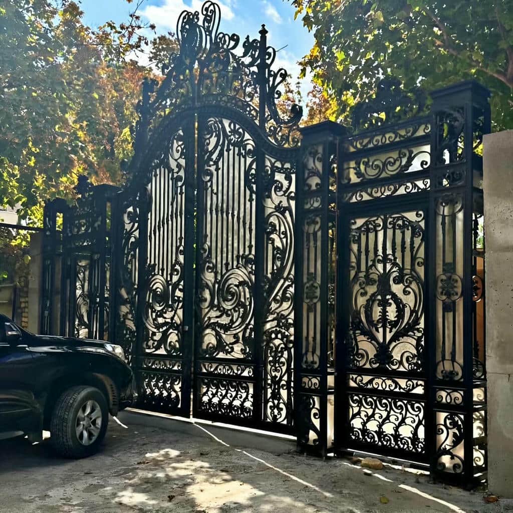 درب حیاط مشکی کنار محوطه درختکاری شده درب حیاط مشکی کنار محوطه درختکاری شده